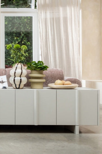 Basu tv-meubel met een Kency vaas gevuld met verse bloemen, sfeervol gepresenteerd in een warme interieursetting